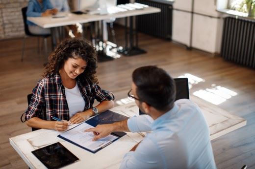 woman signing real estate contract with attorney